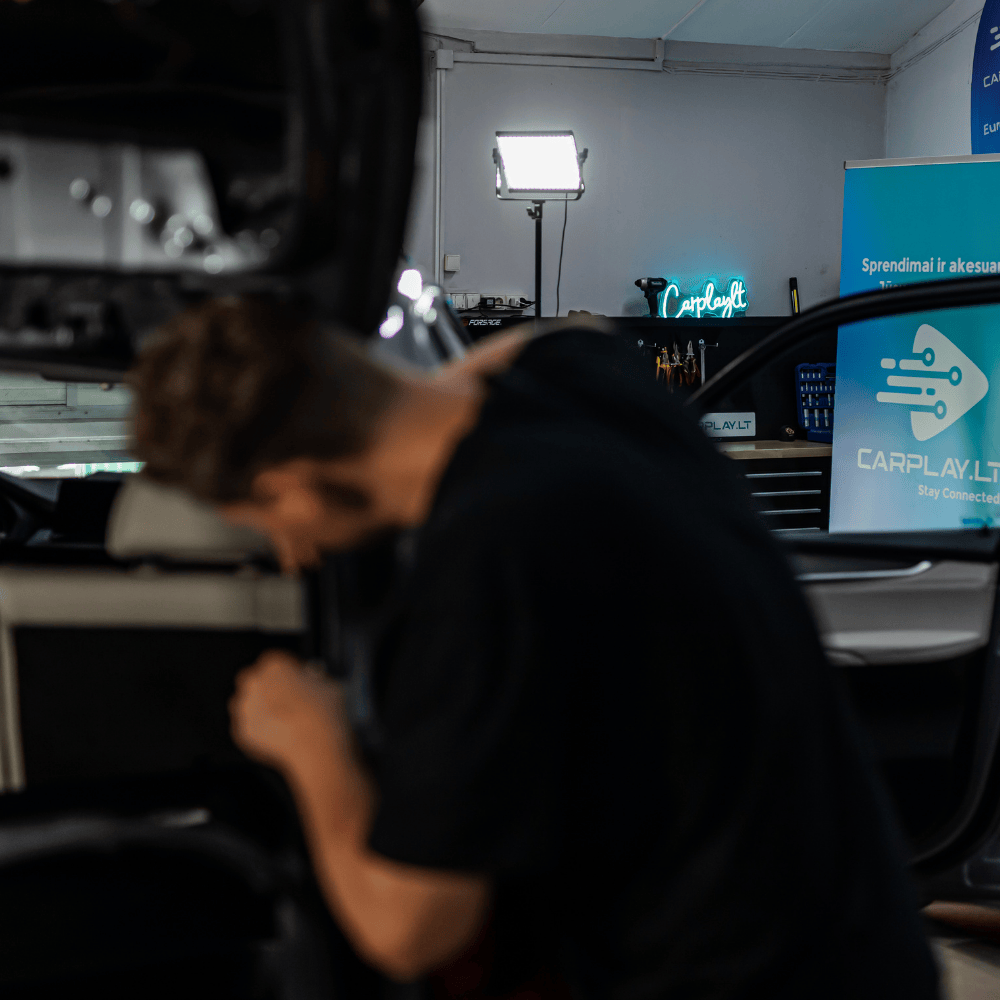 Meistras montuoja automobiliui galinio vaizdo parkavimo kamerą kurios vaizdą rodys per multimedijos ekraną