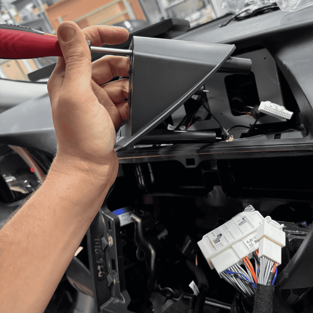 Meistras atsuktuvu nuima automobilio prietaisų skydelį ir atidengia vidinius laidus bei elektronines jungtis.